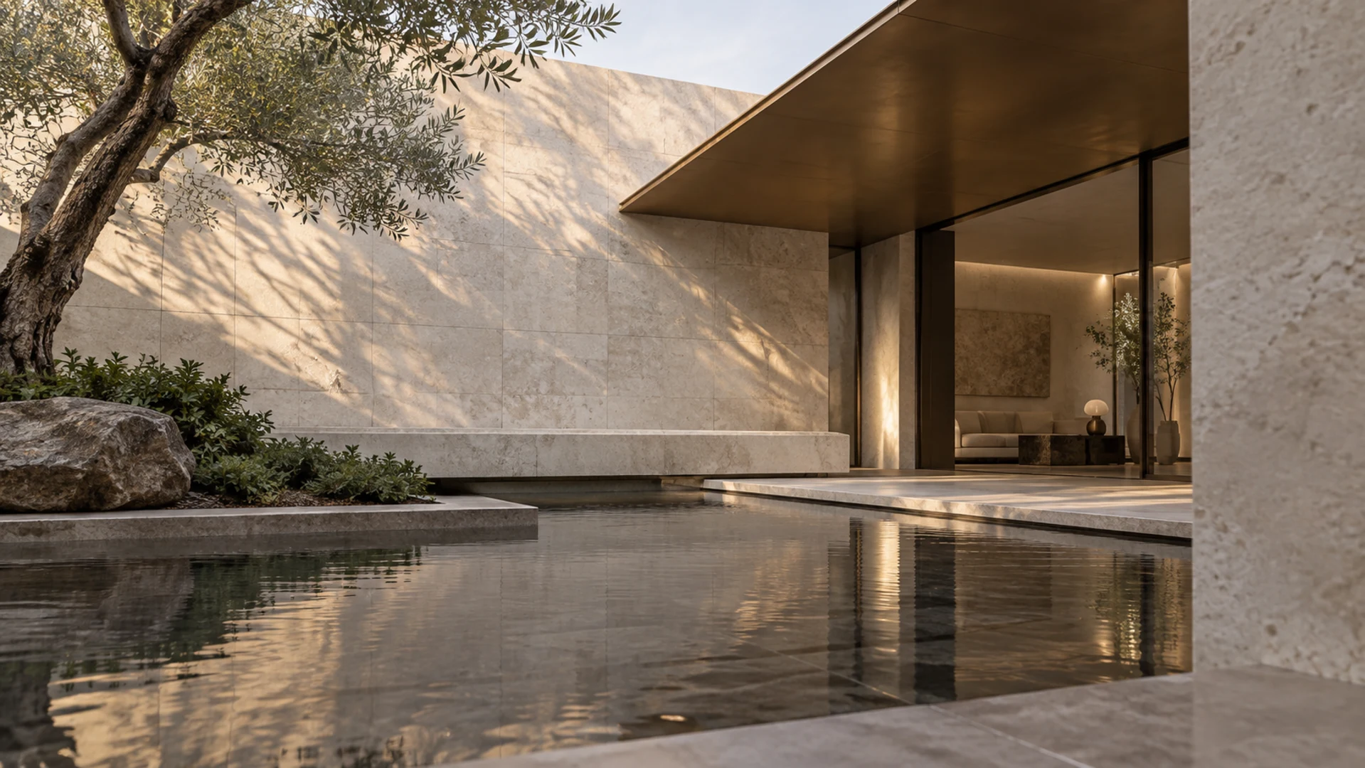 CONTOUR visual study. A warm stone courtyard with a thin bronze soffit and glazed room opens onto still water beneath an olive tree.