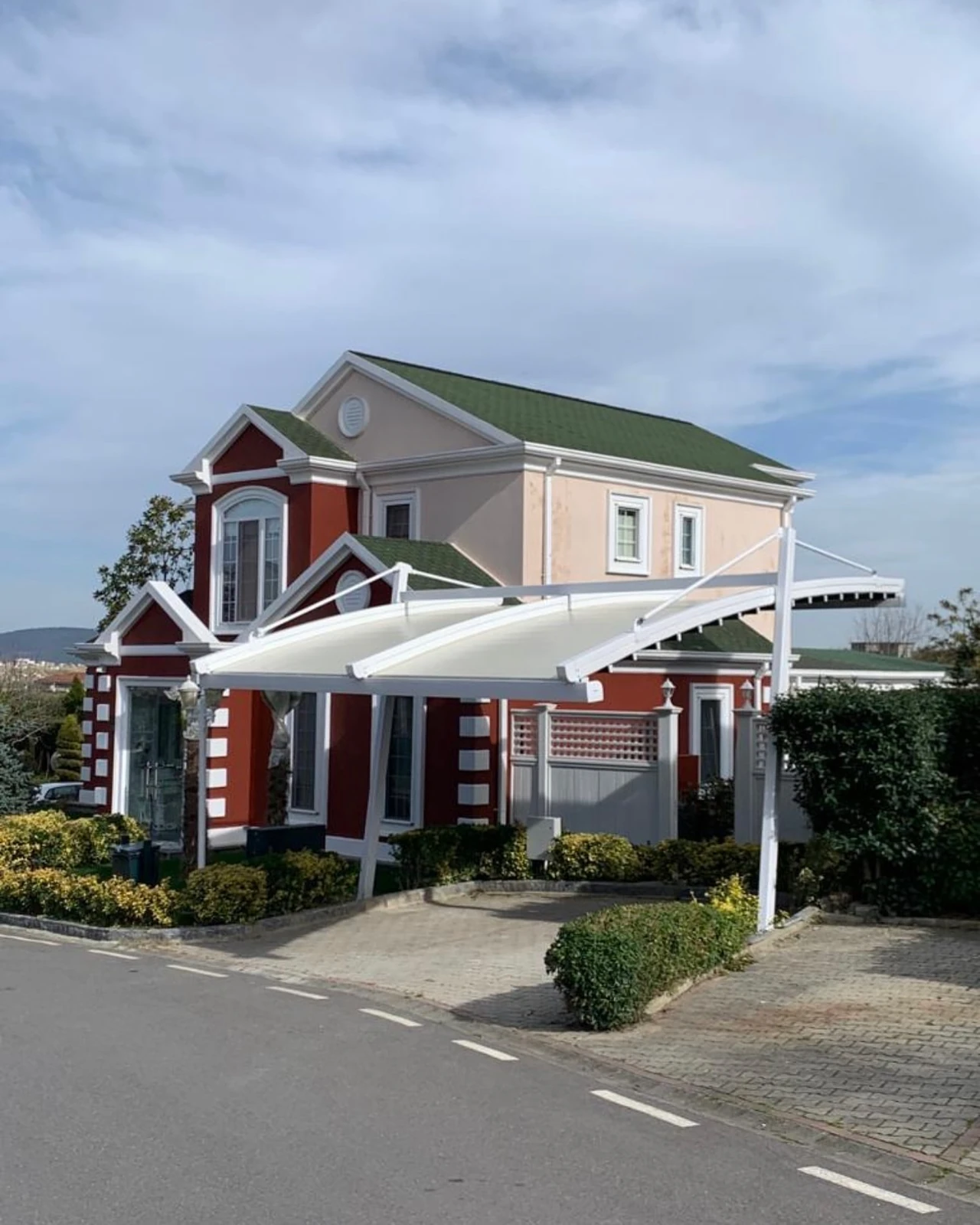 A white retractable canopy extending from a building over a paved forecourt, photographed from the street.